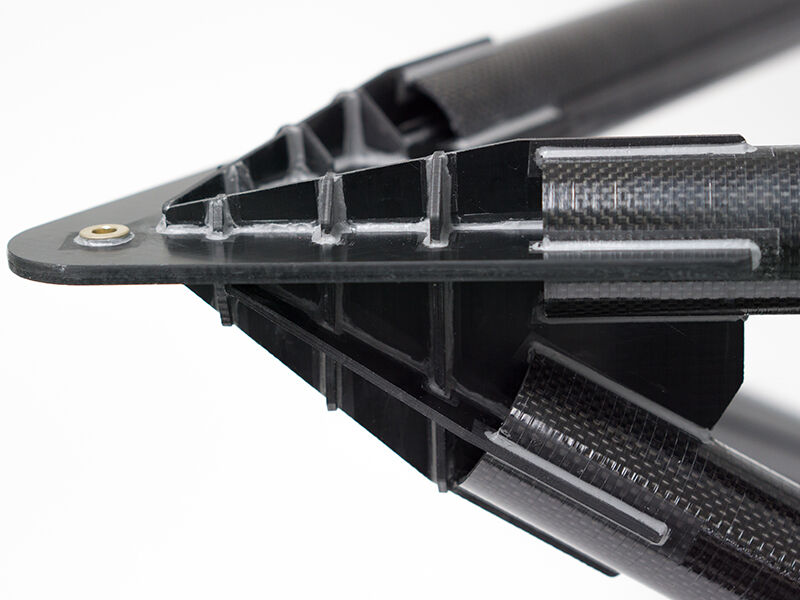 Image shows the completed TMT metrology fixture on a white surface and background. The detail image shows a connection juncture. Several carbon fiber tubes are bonded to a dark metallic and pointed fitting. 